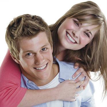 A young couple both show off their Damon Clear Braces, an alternative to traditional metal braces.